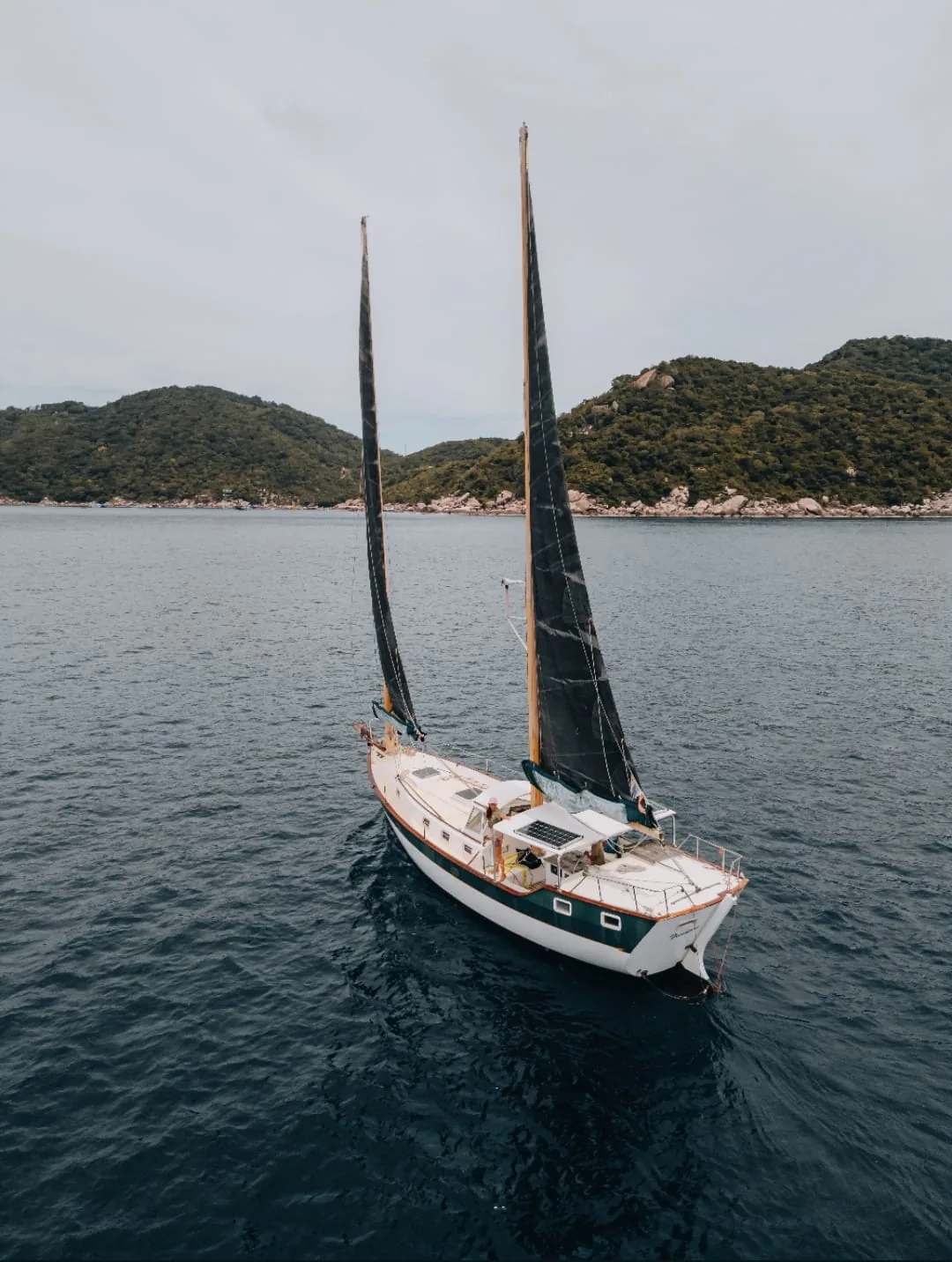 SV Freedom Fargo under sail in front of the hills of Koh Tao